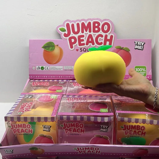 Squishy durazno jumbo amarillo en la mano frente a su exhibidor Jumbo Peach Squishy